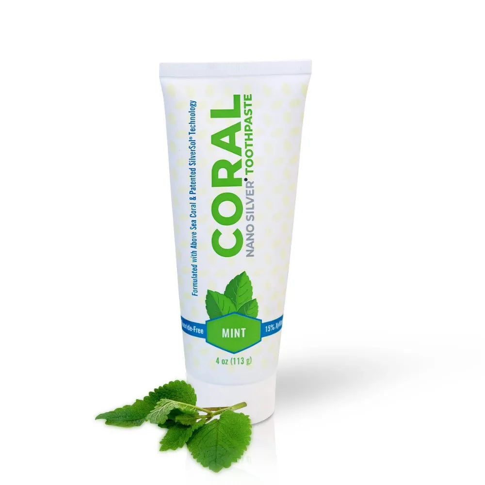 Tube of Coral Nano Silver Toothpaste with mint leaves on a white background
