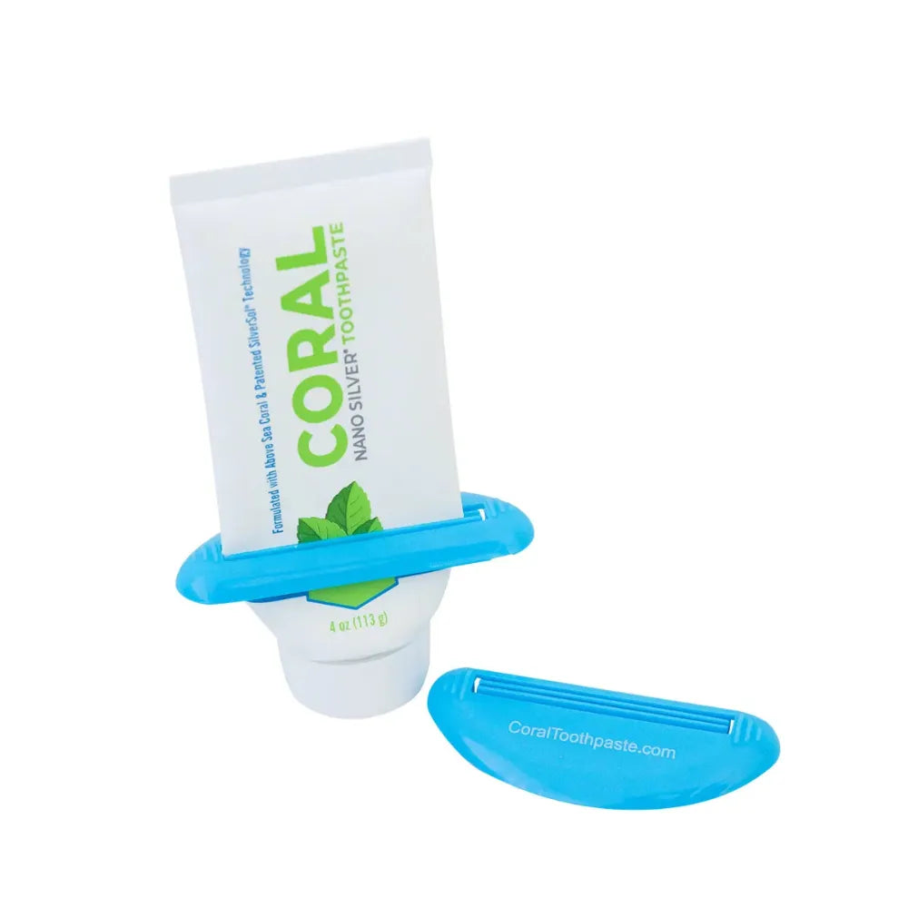 Coral Nano Silver Toothpaste tube in mint flavor displayed with a light blue toothpaste squeezer. The eco-friendly toothpaste contains above-sea coral calcium and nano silver technology to promote oral health and pH balance. Image emphasizes efficient toothpaste use and sustainable packaging from CoralToothpaste.com.