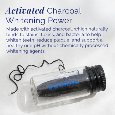 Coral Bamboo Charcoal Mint Floss in a clear glass bottle, featuring activated charcoal floss that helps remove plaque, reduce stains, and freshen breath naturally, displayed with floss strand extended on a white background.