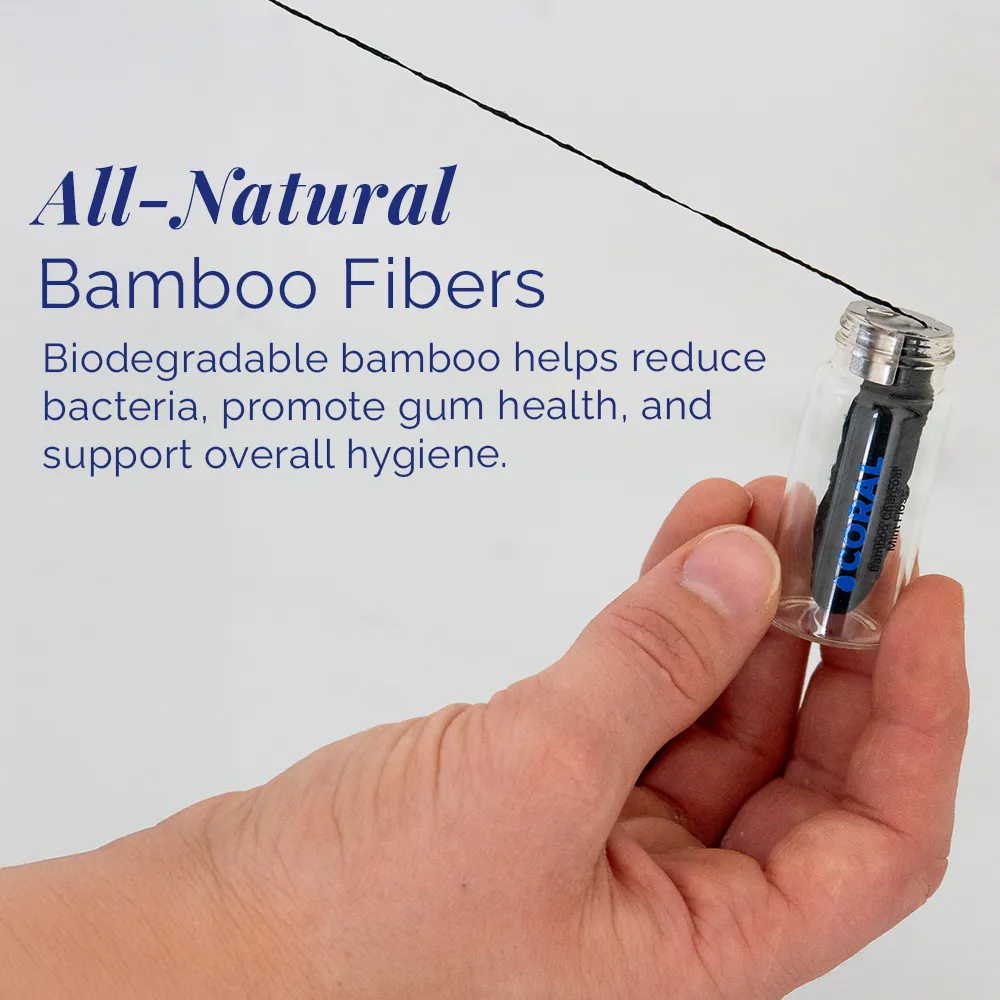 Hand holding Coral Bamboo Charcoal Mint Floss in a reusable glass bottle, featuring all-natural biodegradable bamboo fibers designed to gently clean between teeth, reduce bacteria, and support healthy gums.