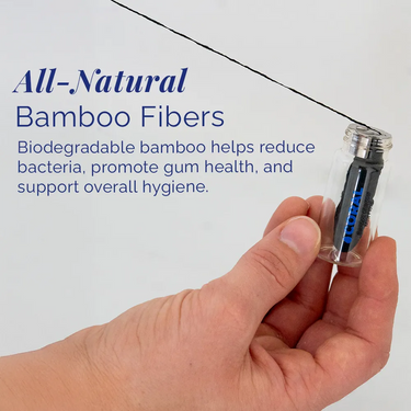 Hand holding Coral Bamboo Charcoal Mint Floss in a reusable glass bottle, featuring all-natural biodegradable bamboo fibers designed to gently clean between teeth, reduce bacteria, and support healthy gums.