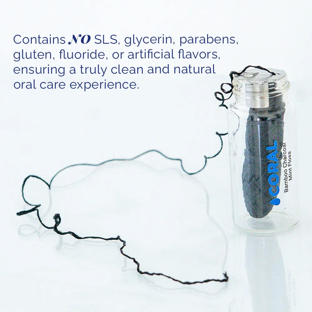 Coral Bamboo Charcoal Mint Floss in a reusable glass bottle with charcoal-infused floss visible, highlighting a clean formula free from SLS, glycerin, parabens, gluten, fluoride, and artificial flavors for a natural oral care routine.