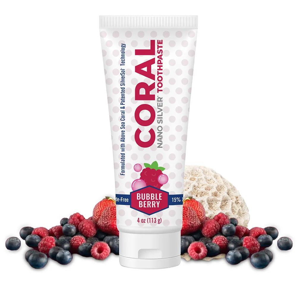 Coral Nano Silver Toothpaste Bubble Berry flavor in 4oz tube, displayed with fresh strawberries, raspberries, blueberries, and a piece of above-sea coral on a white background.