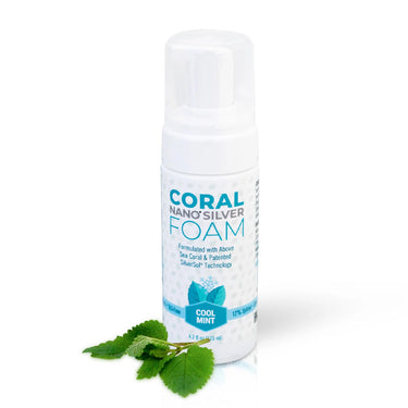 Coral Nano Silver foaming Cool Mint toothpaste in a 4.2 fl oz white pump bottle, formulated with above sea coral and patented SilverSol technology, displayed with fresh mint leaves on a white background.