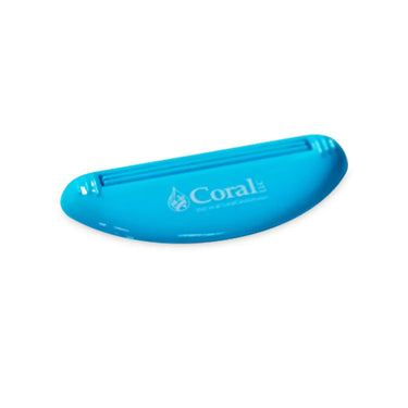 Light blue Coral LLC toothpaste tube squeezer designed for easy dispensing and minimizing waste. Eco-friendly plastic accessory with CoralToothpaste.com logo, ideal for efficiently squeezing toothpaste, creams, or gels from tubes. 