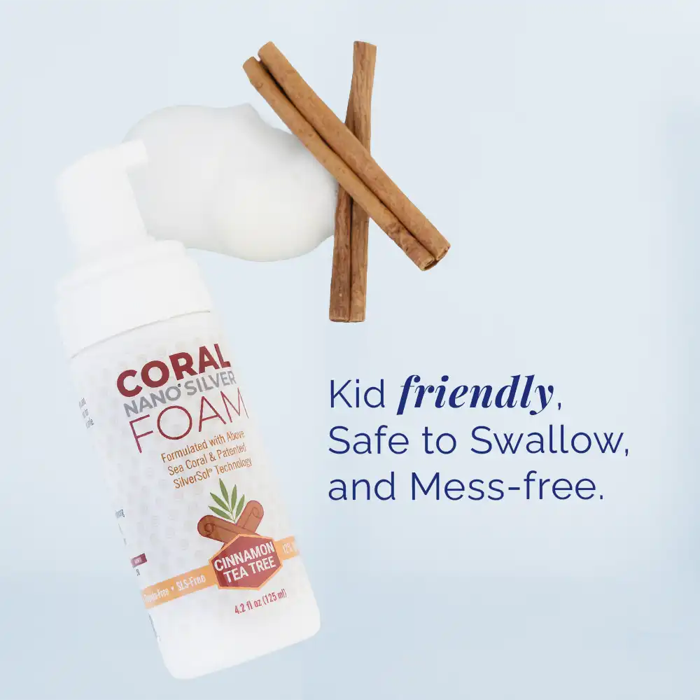 Coral Nano Silver Foaming Toothpaste Cinnamon Tea Tree flavor bottle with foam and cinnamon sticks, featuring text: Kid friendly, safe to swallow, and mess-free. Natural fluoride-free toothpaste formulated with above sea coral and patented SilverSol technology for gentle, child-safe oral care.