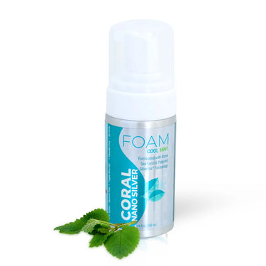 Coral Nano Silver foaming Cool Mint toothpaste with pump dispenser, formulated with above sea coral and patented SilverSol technology, displayed with fresh mint leaves on a white background.