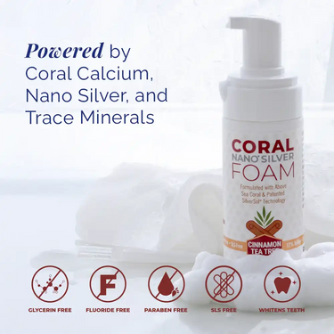 Coral Nano Silver Foaming Toothpaste Cinnamon Tea Tree flavor bottle with foam background and icons highlighting benefits: glycerin-free, fluoride-free, paraben-free, SLS-free, and whitens teeth. Text reads: Powered by coral calcium, nano silver, and trace minerals. Natural fluoride-free oral care with above sea coral and SilverSol technology.