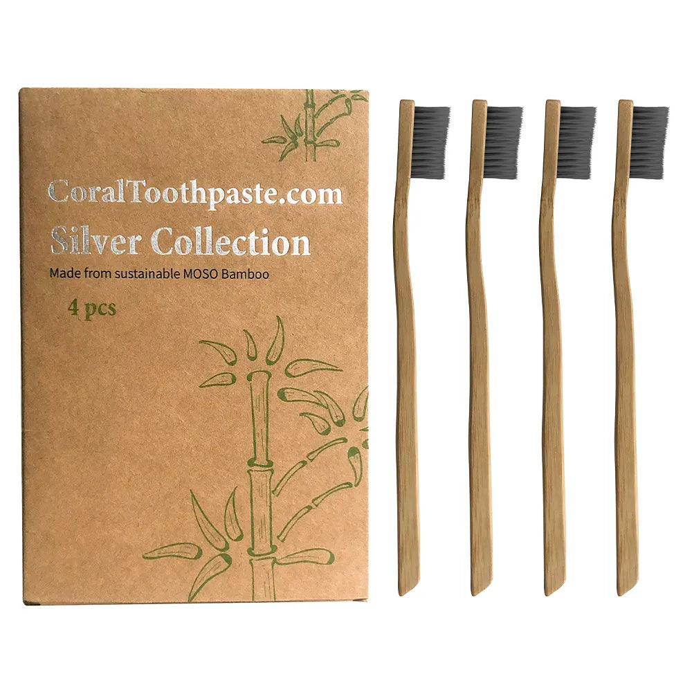 Bamboo toothbrushes with packaging labeled 'CoralToothpaste.com Silver Collection' on a white background.