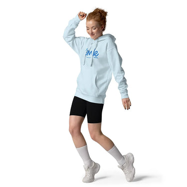 Woman wearing a light blue hoodie with 'Smile' text, black shorts, white socks, and white sneakers on a white background.