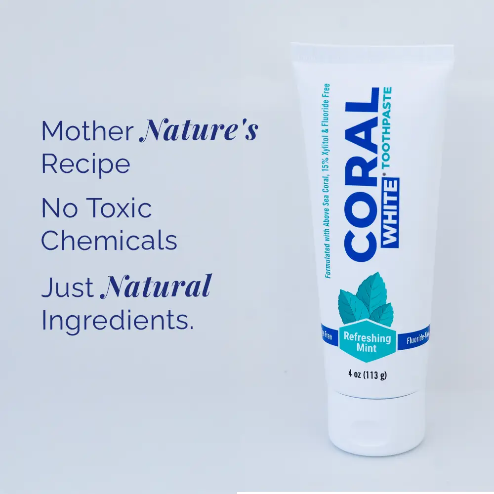Coral White toothpaste tube with text about natural ingredients on a light blue background